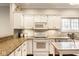 Well-lit kitchen featuring white cabinets, granite countertops, stainless appliances, and tile backsplash at 9740 Logan Ln, Fishers, IN 46037
