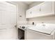 Functional laundry room with modern washer and dryer, ample storage, and clean design at 9740 Logan Ln, Fishers, IN 46037
