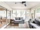 Cozy sunroom featuring large windows, neutral sofas, hardwood floors, and a ceiling fan at 9740 Logan Ln, Fishers, IN 46037