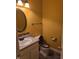 A bathroom with yellow walls, a mirror over the sink, and a toilet at 10523 Dark Star Dr, Indianapolis, IN 46234