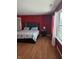 A primary bedroom with red walls and hardwood floors at 10523 Dark Star Dr, Indianapolis, IN 46234