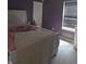 Bedroom with lavender walls, a window with white trim, and a matching bed at 10523 Dark Star Dr, Indianapolis, IN 46234