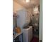 A laundry room with a stacked washer and dryer and shelves with laundry supplies at 10523 Dark Star Dr, Indianapolis, IN 46234