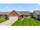 Charming brick home with a well-manicured lawn and attached two-car garage at 10938 E Mount Vernon N Trl, Indianapolis, IN 46229