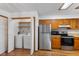 Bright kitchen with stainless appliances, including refrigerator, range, and microwave, with a laundry closet at 10938 E Mount Vernon N Trl, Indianapolis, IN 46229