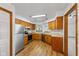 Traditional eat-in kitchen features wood cabinets, stainless steel appliances, and vinyl flooring at 10938 E Mount Vernon N Trl, Indianapolis, IN 46229