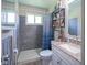 Bathroom featuring a tiled shower, white vanity with granite countertop, and storage shelves at 11 Sayre Dr, Greenwood, IN 46143