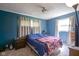 Cozy bedroom with blue walls, a ceiling fan, and curtains over the window for a relaxing retreat at 11 Sayre Dr, Greenwood, IN 46143