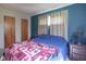 Bedroom with a bed covered with an Oklahoma Sooners blanket, plus side tables, and blue accent wall at 11 Sayre Dr, Greenwood, IN 46143