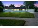 Charming single-story home with a well-manicured lawn and detached two-car garage at dusk at 11 Sayre Dr, Greenwood, IN 46143