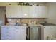 Kitchen featuring white cabinets, light countertops, stainless steel dishwasher and washer at 11 Sayre Dr, Greenwood, IN 46143