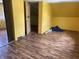 Bright, unfinished bedroom featuring wood-look flooring and vibrant yellow walls, awaiting your personal touch at 1163 Groff Ave, Indianapolis, IN 46222