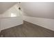 Finished attic space boasts gray wood-look flooring, bright white walls, and a small window at 12003 Broadway St, Indianapolis, IN 46236