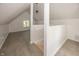 Finished attic features gray flooring, bright white walls, and a small window at 12003 Broadway St, Indianapolis, IN 46236