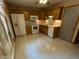 Traditional-style kitchen with tile flooring, wooden cabinets, and white appliances ready for meal preparation at 1219 Lansdowne Rd, Indianapolis, IN 46234