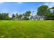 Large green lawn overlooking the property, which includes a spacious garage and custom playground at 12196 N Beth Ann Dr, Camby, IN 46113