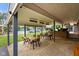 Covered outdoor patio with tables, chairs, and a view of the backyard pool at 12196 N Beth Ann Dr, Camby, IN 46113