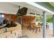 Outdoor patio with covered seating area, TV, and stone landscaping at 12196 N Beth Ann Dr, Camby, IN 46113