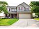 Charming two-story home with a well-manicured lawn, brick accents, and a two-car garage at 1242 Flatrock Dr, Anderson, IN 46013