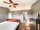 A light filled main bedroom boasts wood flooring, light gray walls and a ceiling fan at 1242 Flatrock Dr, Anderson, IN 46013