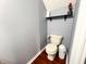Small powder room featuring a low-flow toilet, floating shelves, and wood-look flooring at 1242 Flatrock Dr, Anderson, IN 46013