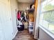 A walk-in closet has clothes, bags, and storage containers and a window at 1242 Flatrock Dr, Anderson, IN 46013