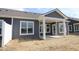 Rear exterior view of a home with gray siding, white trim and a covered patio at 12524 Morning Ridge Way, Noblesville, IN 46060