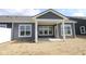 Rear exterior view of a home with gray siding, white trim and a covered patio at 12524 Morning Ridge Way, Noblesville, IN 46060