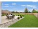 Expansive backyard featuring an outdoor dining area, lush green lawn, and a privacy fence, ideal for entertaining at 12845 Touchdown Dr, Fishers, IN 46037