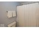 Clean, simple bathroom featuring a white toilet, towel rack with fresh towels, and shower with a white curtain at 12845 Touchdown Dr, Fishers, IN 46037