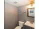 Cozy half bathroom featuring a gray vanity, decorative mirror, and charming wall decor at 12845 Touchdown Dr, Fishers, IN 46037