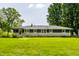Spacious backyard view of charming home with stone and dark siding and manicured green lawn at 130 N High School Rd, Indianapolis, IN 46214