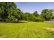 Lush backyard featuring a spacious green lawn and mature trees at 130 N High School Rd, Indianapolis, IN 46214