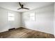 Spacious bedroom featuring wood floors, two windows and a ceiling fan at 130 N High School Rd, Indianapolis, IN 46214