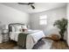 Inviting bedroom features a metal bed frame, stylish lamps, a ceiling fan, and green accents at 130 N High School Rd, Indianapolis, IN 46214
