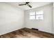 Bright bedroom with hardwood floors, white walls, ceiling fan, and a window offering natural light at 130 N High School Rd, Indianapolis, IN 46214