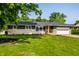 Charming single-story home featuring stone and dark siding, and a well-manicured lawn at 130 N High School Rd, Indianapolis, IN 46214