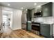 Open kitchen features stainless steel appliances, green cabinets, and an adjacent laundry room at 130 N High School Rd, Indianapolis, IN 46214