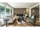 Sunlit living area featuring stylish furniture, modern fireplace, and wood-look flooring at 130 N High School Rd, Indianapolis, IN 46214