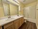 Hall bathroom featuring a double sink vanity, large mirror, and shower with glass doors at 1442 Bank Pl, Indianapolis, IN 46231