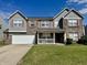 Charming two-story home with brick and gray siding, complemented by a well-manicured lawn at 1442 Bank Pl, Indianapolis, IN 46231