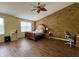 Spacious main bedroom showcasing laminate flooring, a ceiling fan, and a large decorative wall at 1442 Bank Pl, Indianapolis, IN 46231