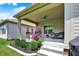 Covered back porch with seating, ceiling fan, potted plants, and stairs leading to the landscaped backyard at 1457 Birdsong Dr, Westfield, IN 46074