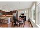 A dining area with wood floors features large windows, and is adjacent to the kitchen with a pendant light at 1457 Birdsong Dr, Westfield, IN 46074