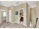 Upstairs hallway with carpet flooring, neutral walls, and doorways leading to rooms, with a view of the staircase at 1457 Birdsong Dr, Westfield, IN 46074