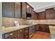 A kitchen features granite counters, backsplash, stainless microwave, cooktop, oven, and dark wood cabinets at 1457 Birdsong Dr, Westfield, IN 46074