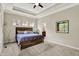 A main bedroom features neutral walls, carpet, a tray ceiling with fan, and ensuite bathroom at 1457 Birdsong Dr, Westfield, IN 46074