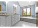 Bright bathroom features a soaking tub, granite countertops, and stylish fixtures at 15120 Romalong Ln, Carmel, IN 46032