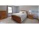 Comfortable bedroom featuring light gray walls, soft carpet, and wooden furniture at 15120 Romalong Ln, Carmel, IN 46032