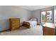 Charming bedroom with natural light, a cozy bed, and a classic wooden dresser near the window at 15120 Romalong Ln, Carmel, IN 46032